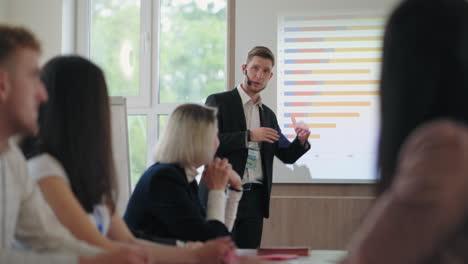 male-marketing-specialist-is-speaking-on-business-meeting-in-big-IT-company-young-man-with-headset