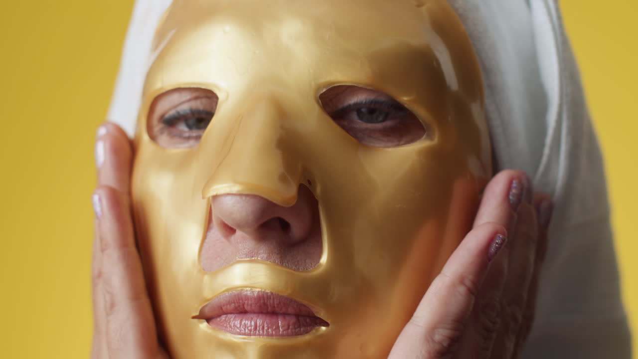 Reife Frau glättet eine feuchtigkeitsspendende Tuchmaske auf dem Gesicht