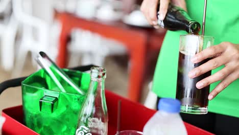 person pouring cola into a glass