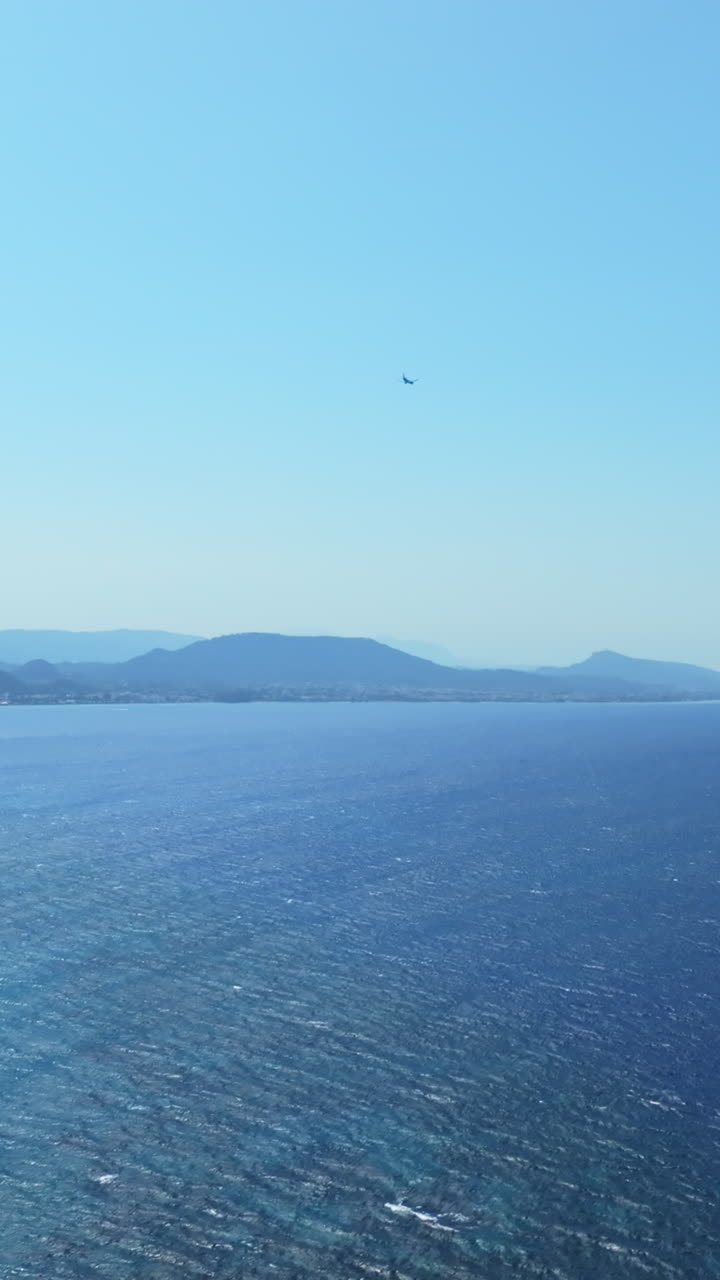 Aerial portrait following a plane moving over the coast of Rhodes, Greece