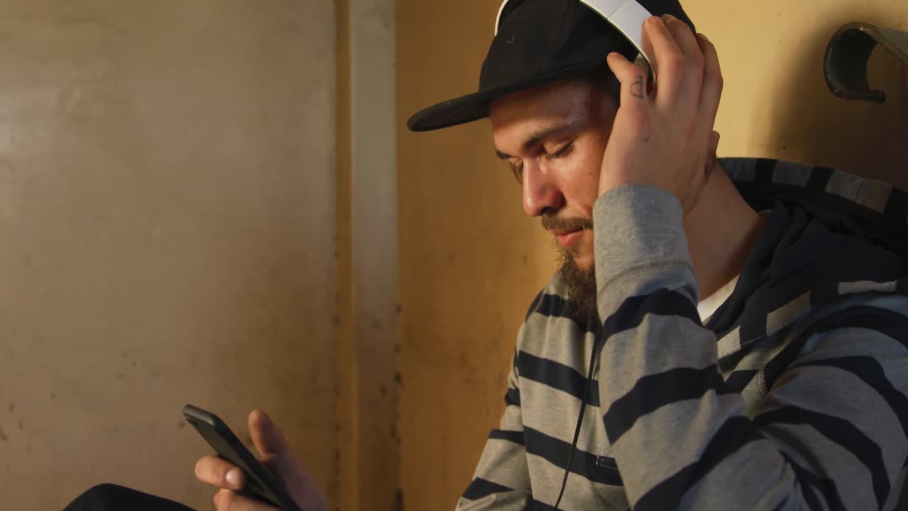 Young man listening to music in empty warehouse