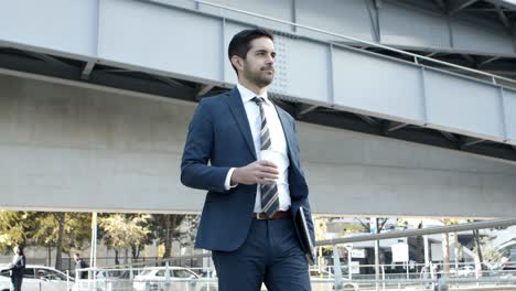 young businessman with coffee to go and laptop