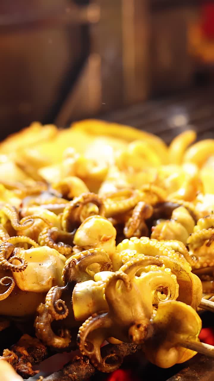 Baby squid skewers grilling over open flame at night market, warm lighting, close-up view