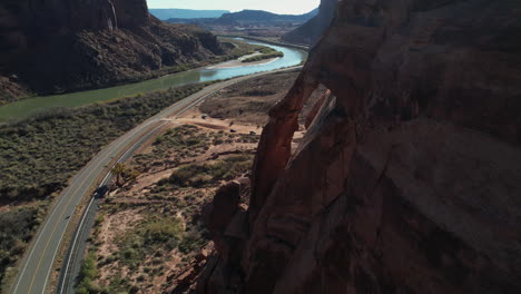 vista aérea cinematográfica de la ruta estatal de utah por el río colorado y formaciones rocosas de arenisca cerca de moab, ee.uu.