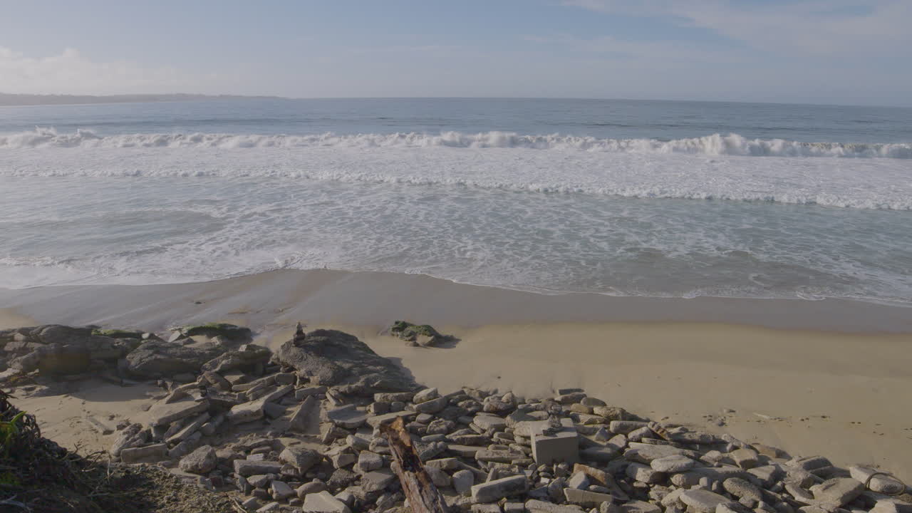 toma en cámara lenta de una playa rocosa en un día soleado en la playa estatal del puerto deportivo de la bahía de monterey de california