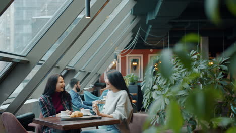 two women having coffee and conversation in a modern cafe