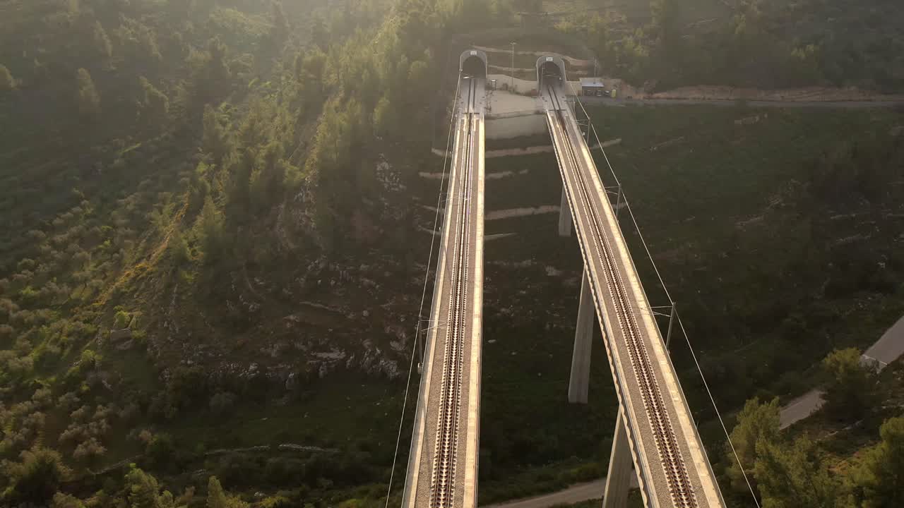 Aerial View of Train Bridge over Mountainous Terrain with Tunnels