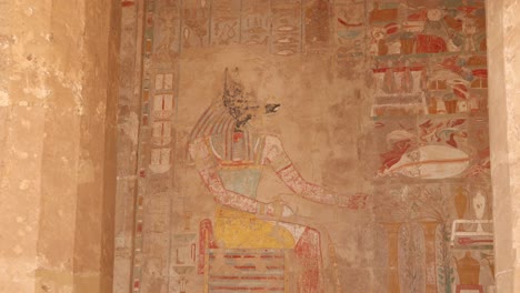 jeroglíficos coloridos de anubis bordean la pared de los antiguos templos y tumbas en el valle de los reyes y el templo de hatshepsut