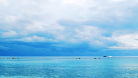 Ein-Schnellboot,-Das-An-Einem-Hellen-Sonnigen-Tag-Mit-Blauem-Himmel-Und-Wolken-Im-Hintergrund-Durch-Die-Wasser-Der-Malediven-Rauscht---Weite-Schwenkaufnahme