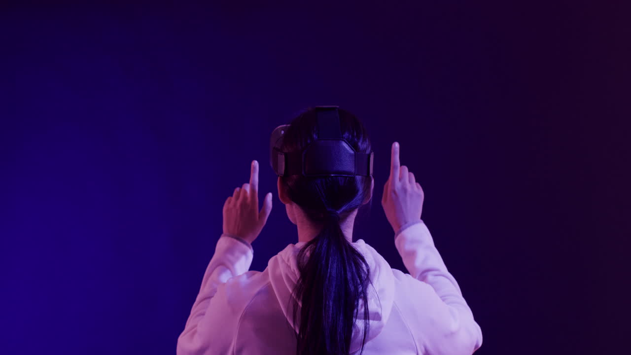 donna asiatica che usa le cuffie vr, tocca la schermata virtuale su sfondo blu, slow motion