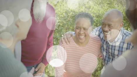 animación de puntos de luz sobre diversas personas mayores sonriendo en el jardín