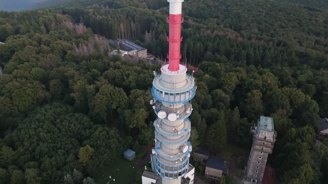 Orbital drone view around the antenna forested Kékestető TV Tower with the surrounding Mátra Mountains in Hungary