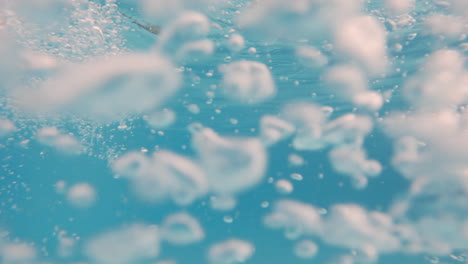 cinematic underwater slow motion shot of air bubbles in clear blue waters in 4k, 120fps, slomo