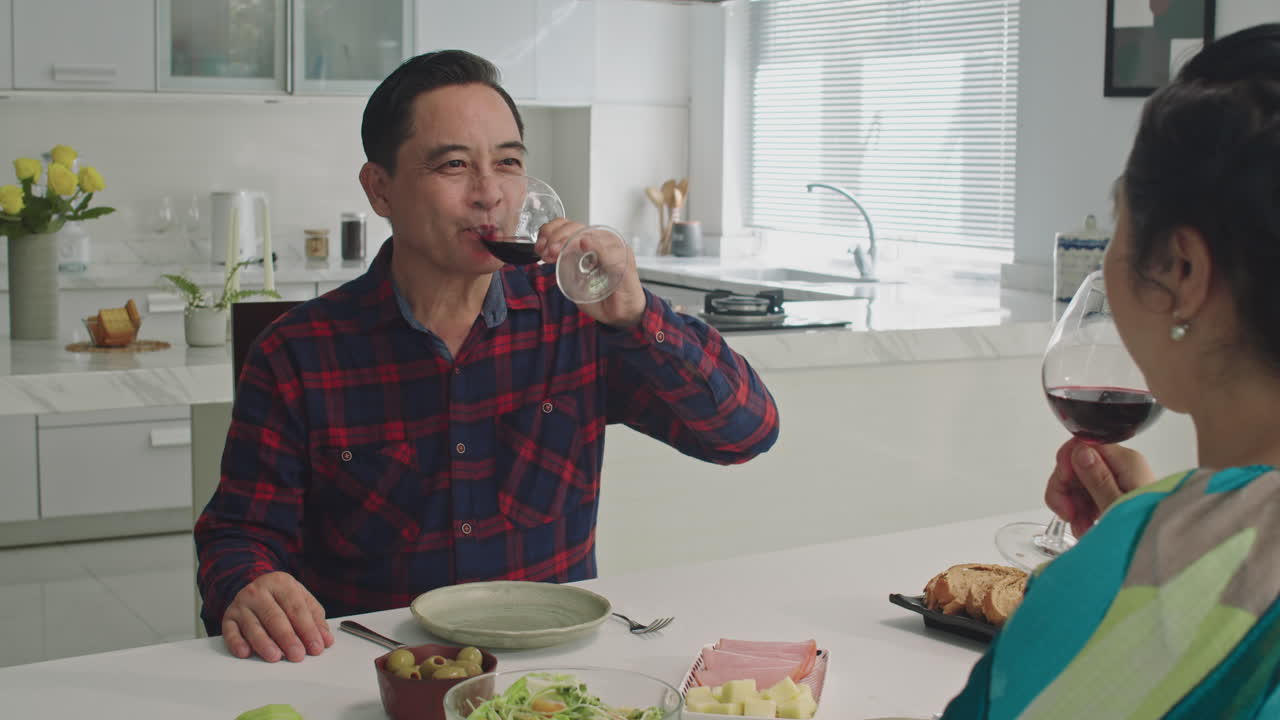 Aged Man and Woman Celebrating Wedding Anniversary with Red Wine