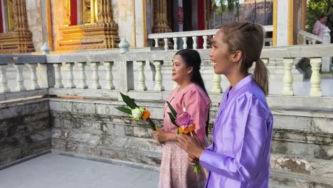 women in traditional thai clothing at a temple