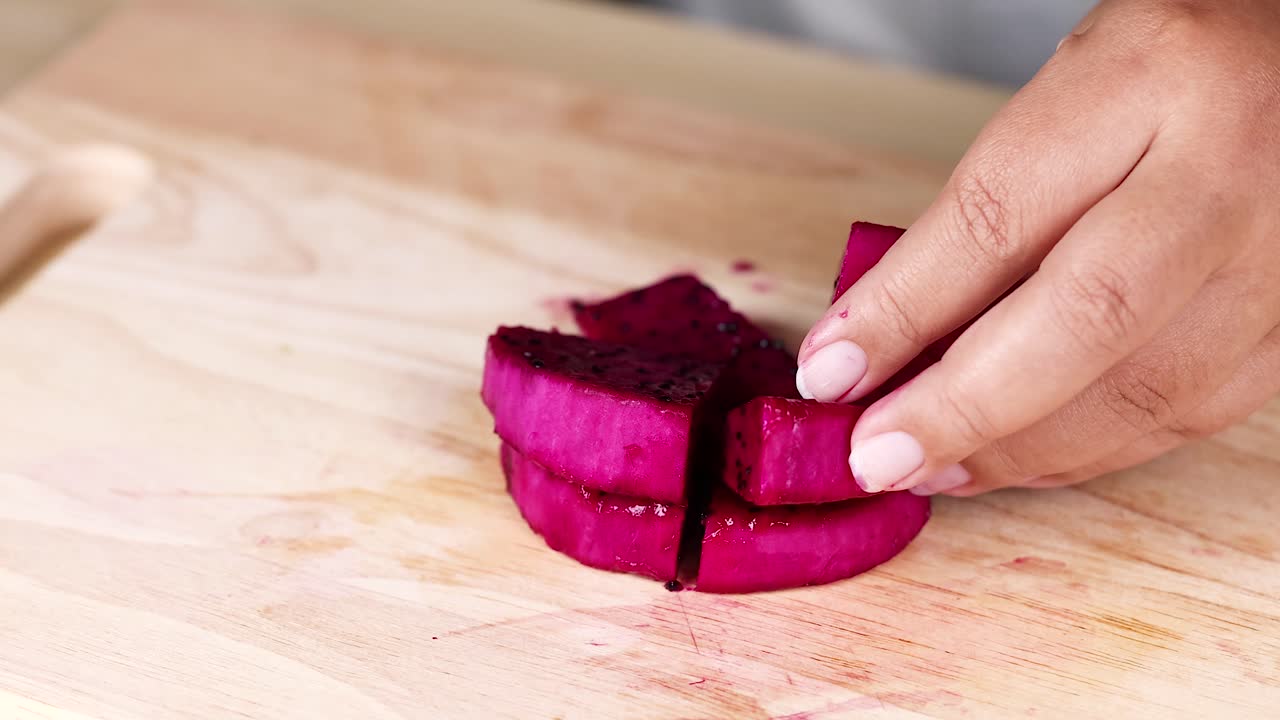 cortando a mano la fruta del dragón en pedazos limpios