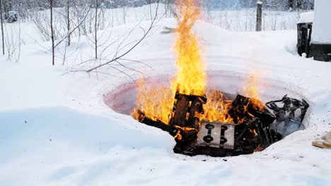 quemando leña en un pozo de fuego cubierto de nieve