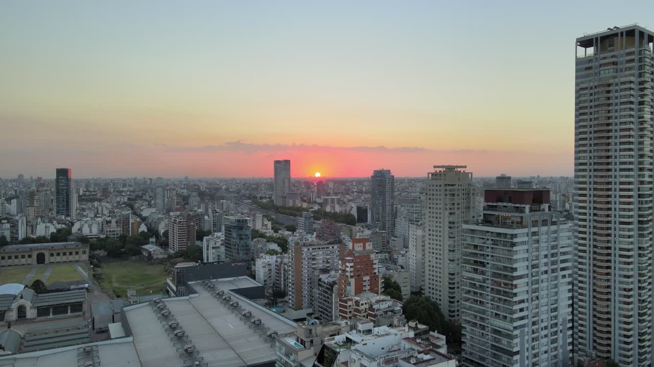toma aérea de establecimiento de la ciudad de buenos aires y la puesta de sol en el fondo
