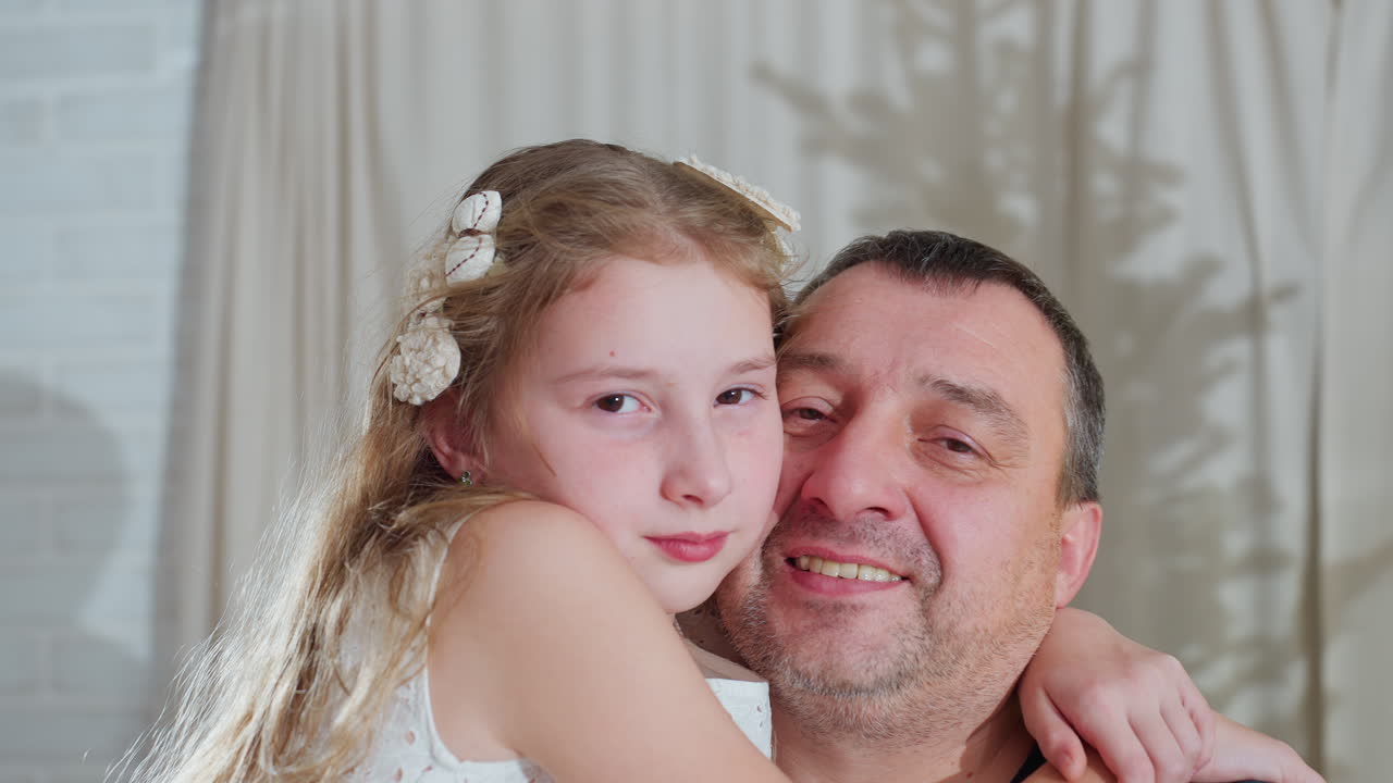 Close up view of loving dad and daughter embracing and joining heads together smiling warmly during joyful family holiday moment inside cozy decorated home with festive atmosphere