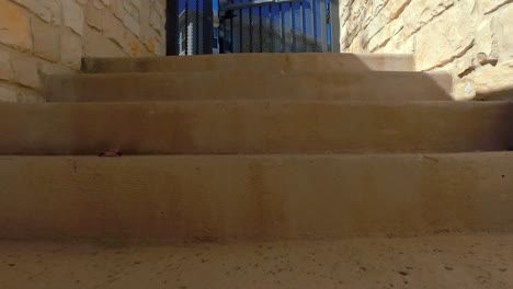 vista en primera persona subiendo escaleras para salir del área de la piscina y abriendo la puerta en la parte superior