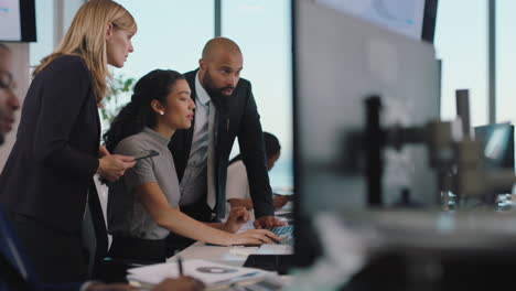 business woman team leader meeting with colleagues using computer pointing at screen office manager sharing ideas helping coworkers discussing strategy in corporate workplace