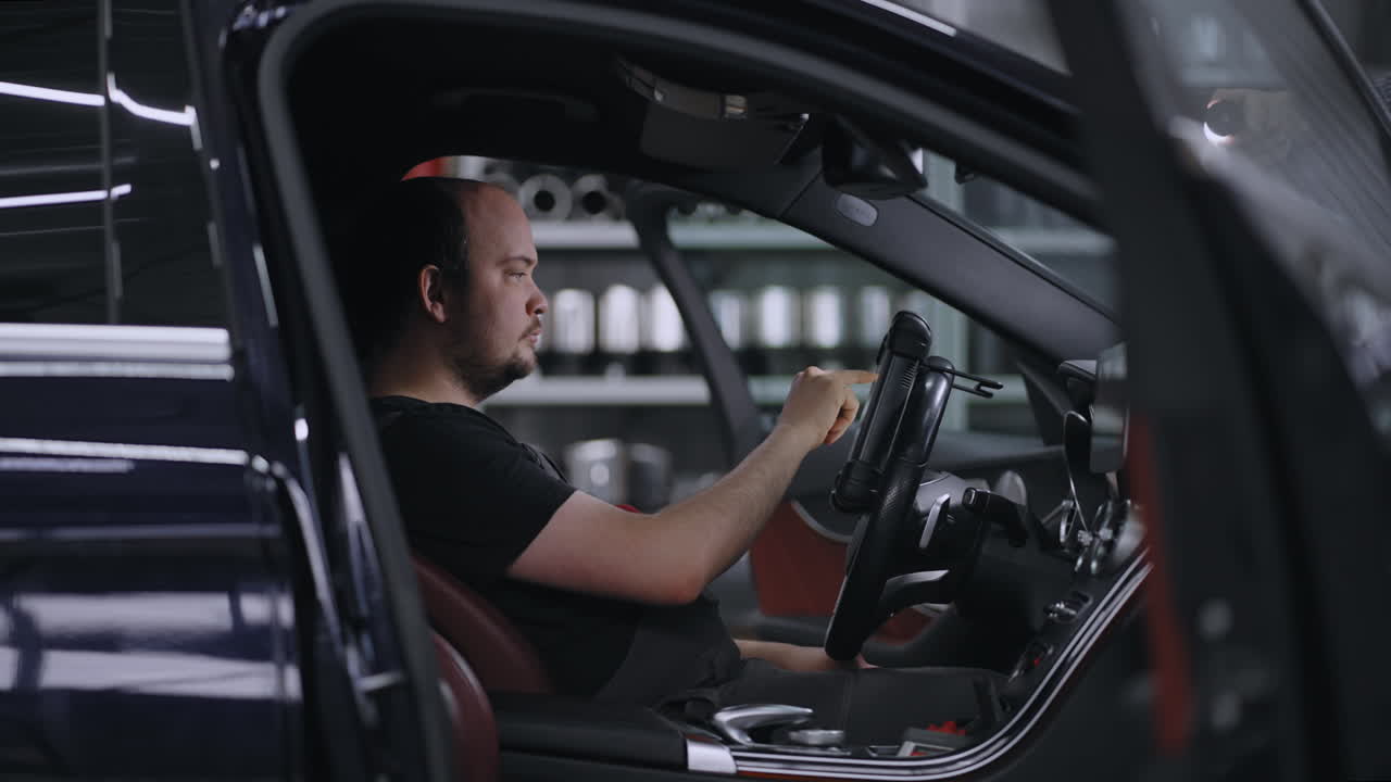 male Mechanic Uses a Tablet Computer with an Augmented Reality Diagnostics Software. Specialist Inspecting the Car in Order to Find Broken Components Inside. male uses laptop for diagnostics vehicle