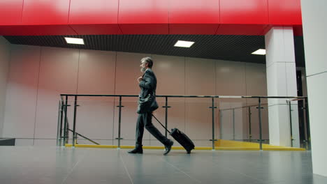 businessman walking through modern airport terminal