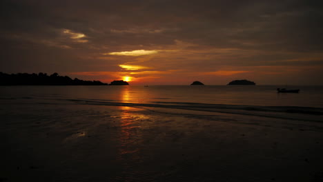 Sunset-in-Thaïlande,-with-fish-boat-and-red-sun-in-background