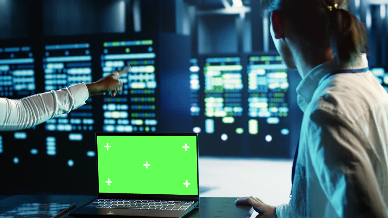 Coworkers use green screen laptop for AI