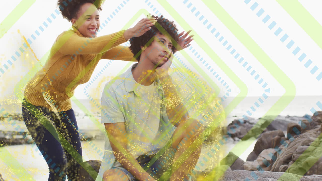 Smiling woman playfully placing hands on man's head over abstract pattern animation