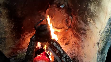 primer plano de cocinar la cena en una olla sobre un fuego de madera en una chimenea de ladrillo en una cocina tradicional-2