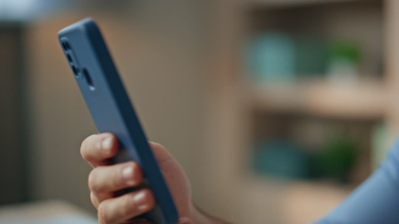 Office man surfing smartphone internet at workplace closeup. Freelancer browsing