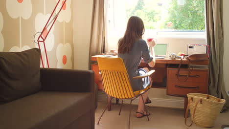 a businesswoman sitting at her desk drinking