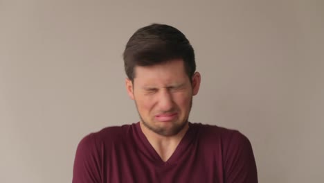 young man making faces of disgust and negating, medium close-up still shot