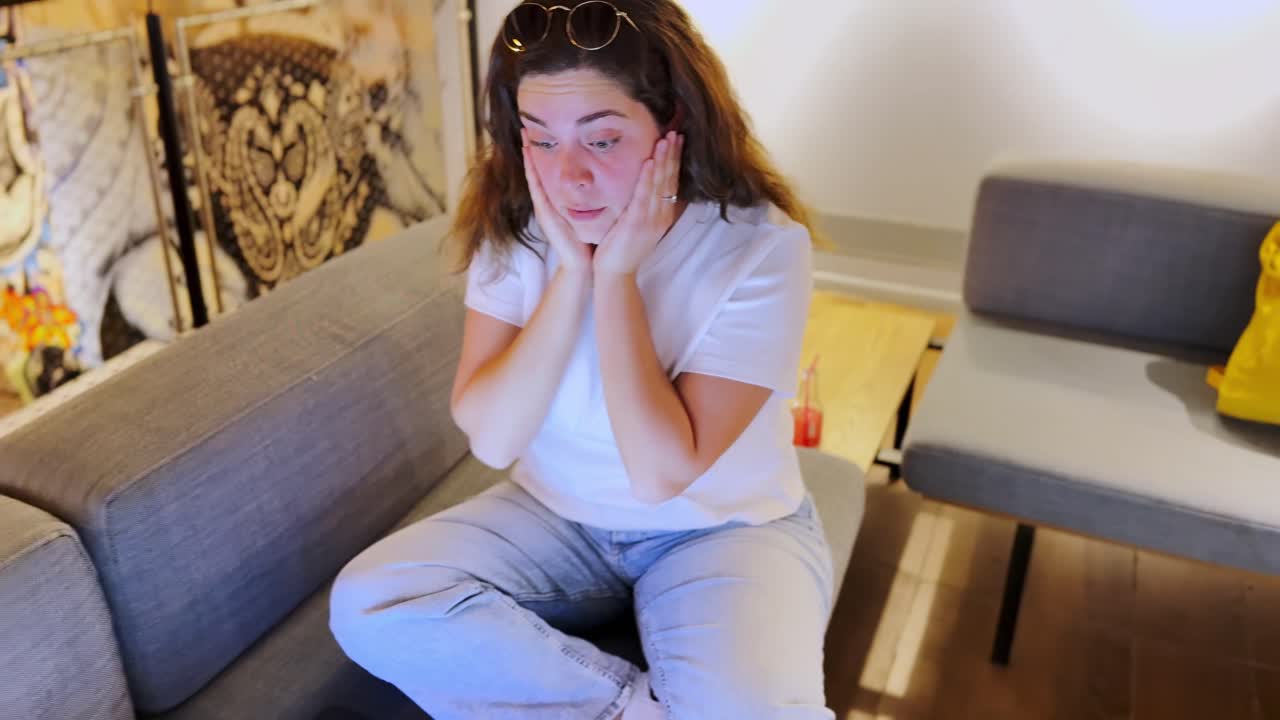 Donna stressata che piange mentre lavora al laptop.