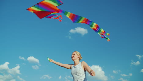 Happy-Woman-As-A-Child-Plays-With-An-Air-Kite-On-A-Background-Of-Pure-Blue-Sky-4K-Video
