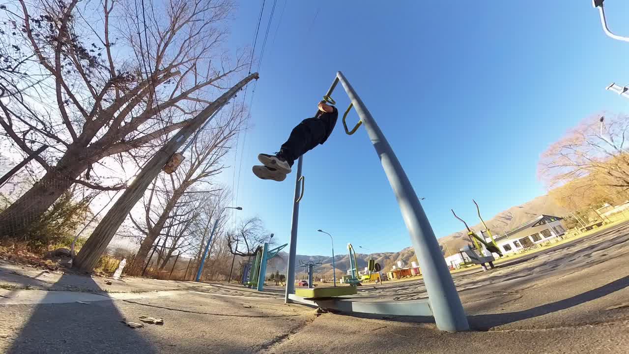 Young man doing calisthenics in the street. Fisheye view