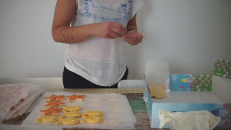 imágenes de una mujer caucásica haciendo galletas de pescado