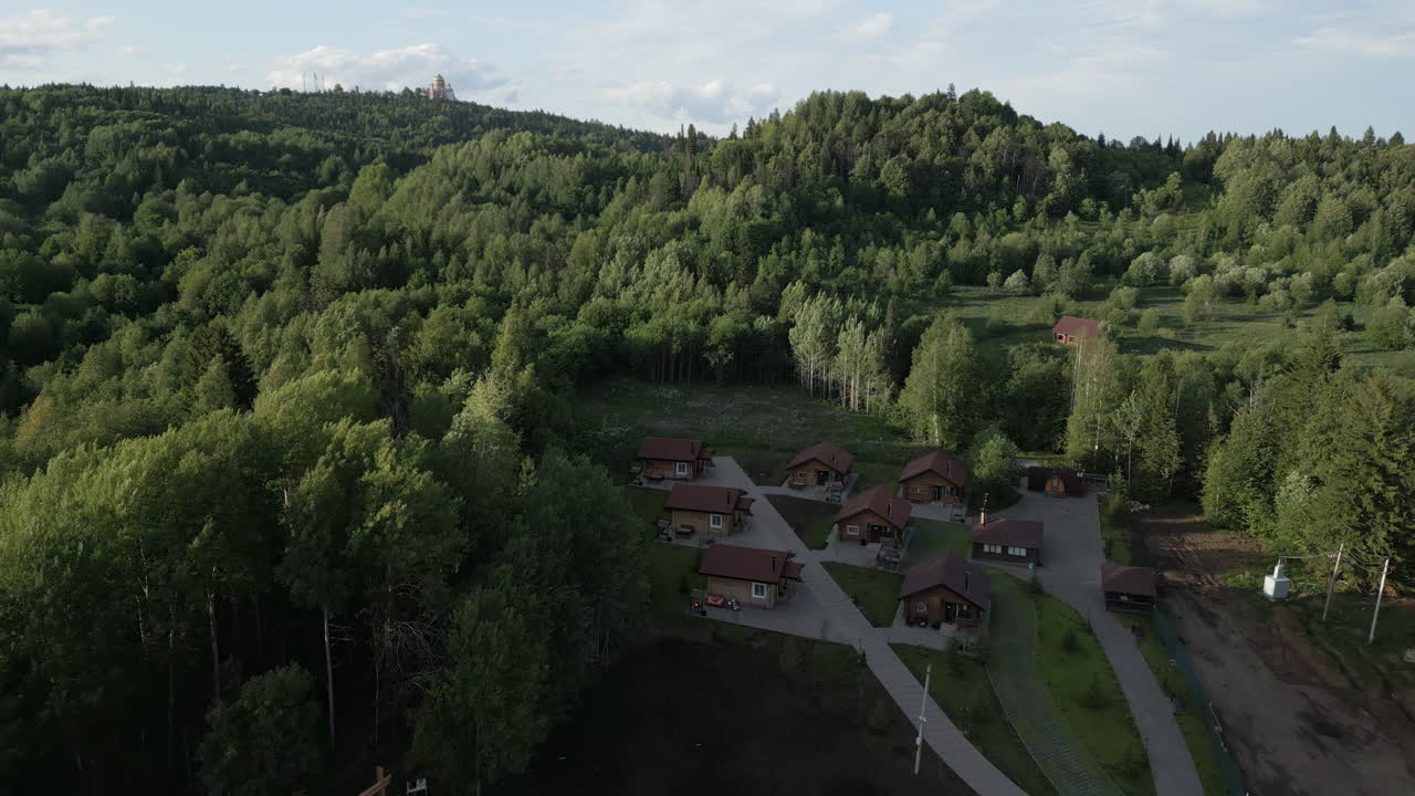 Widok z lotu ptaka na zalesiony teren z domami i kościołem