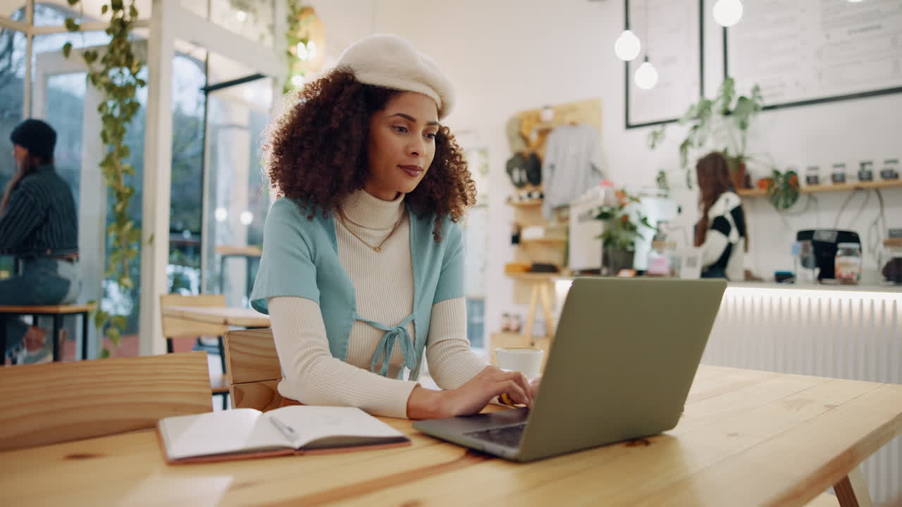Woman working on laptop in cafe