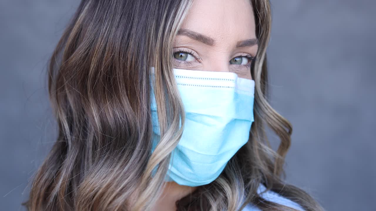 una mujer despejada con mascarilla posa en un retrato de cerca durante la epidemia pandémica del coronavirus covid19