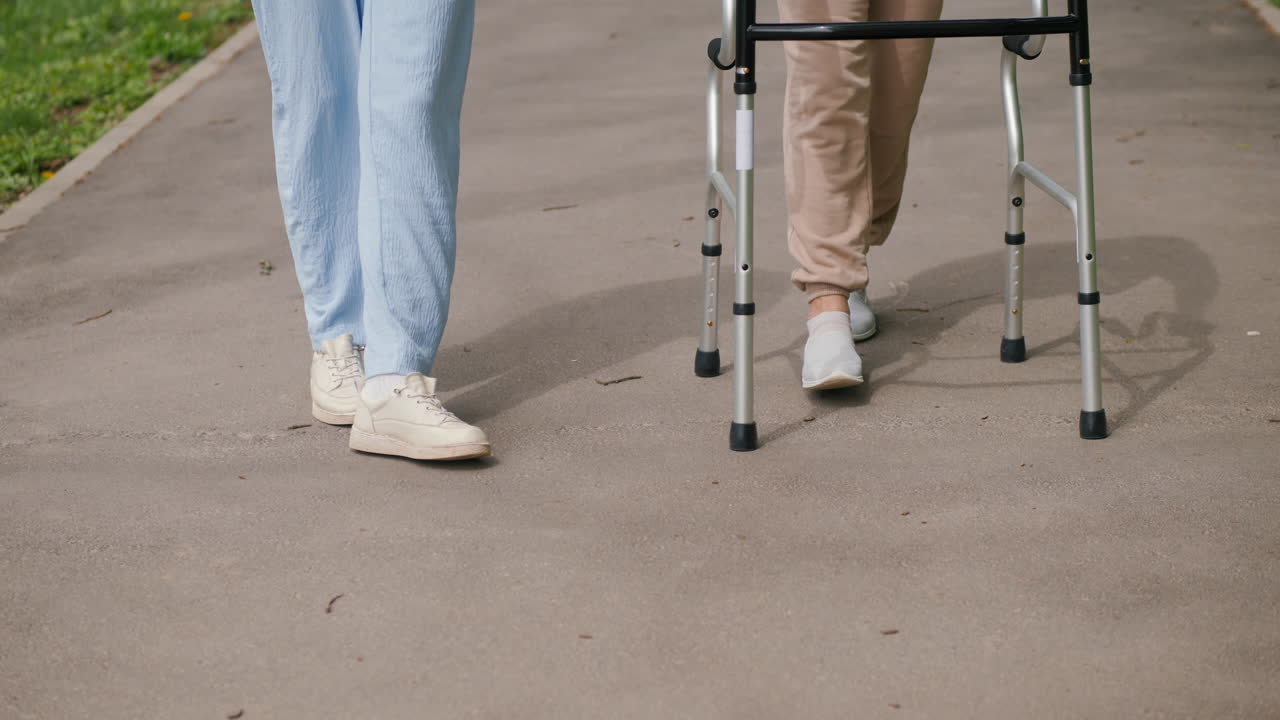 보행기 를 들고 노인 을 돕는 여자