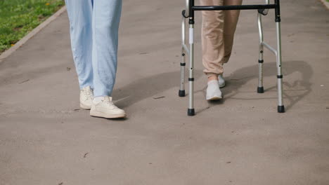 woman assisting elderly person with a walker