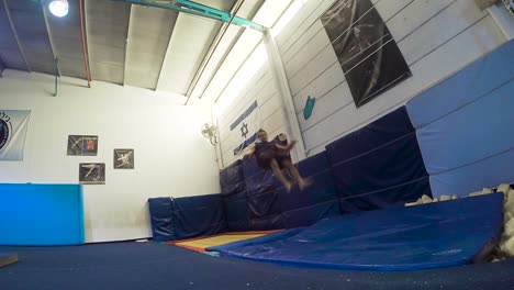 a slow motion still shot of a guy doing flips from the trampoline landing and winning having fun and working out in 60fps