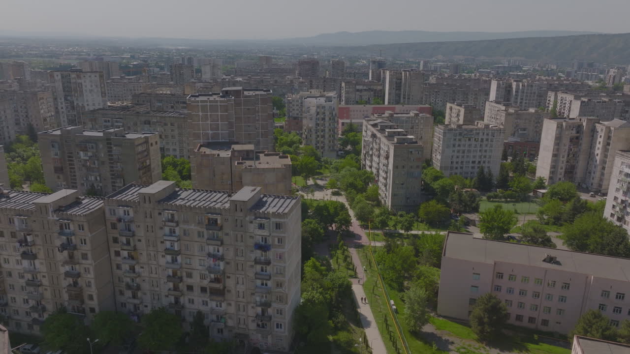 Luftfoto af boligbygninger fra sovjettiden i arkitektonisk stil og beboelsesblokke med parkerede biler, Tbilisi, Georgien.