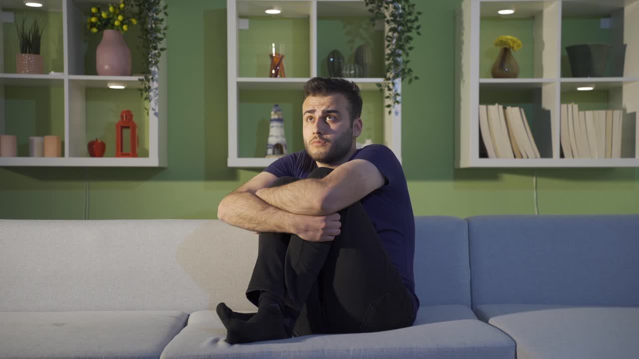 un joven deprimido solo en casa.