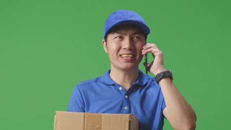 配達人がパッケージと電話で話している