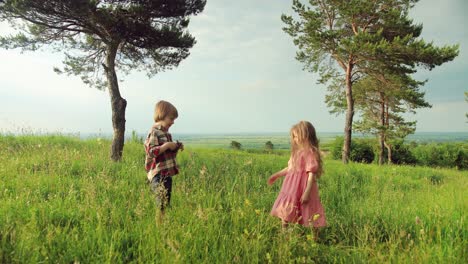 Full-length-view-of-a-caucasian-little-girl-smiling-and-posing-while-her-brother-taking-picture-in-the-park-on-a-sunny-day