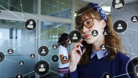 Network-connections-animation-over-woman-talking-on-smartphone-in-office