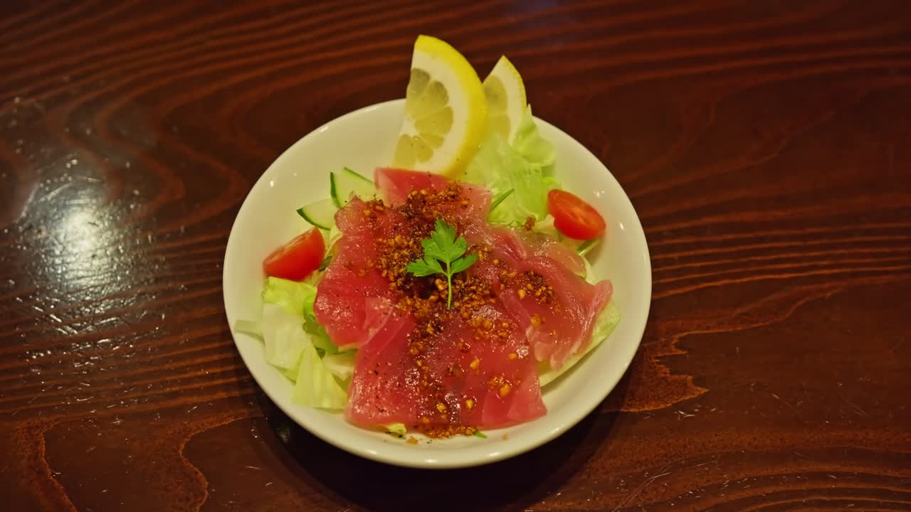 Carpaccio de Salmón con Ensalada Fresca y Limón en un Acogedor Restaurante en Japón, Primer Plano de Comida.